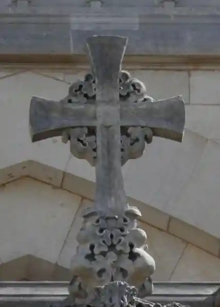 A cross with curly sun like design in the middle